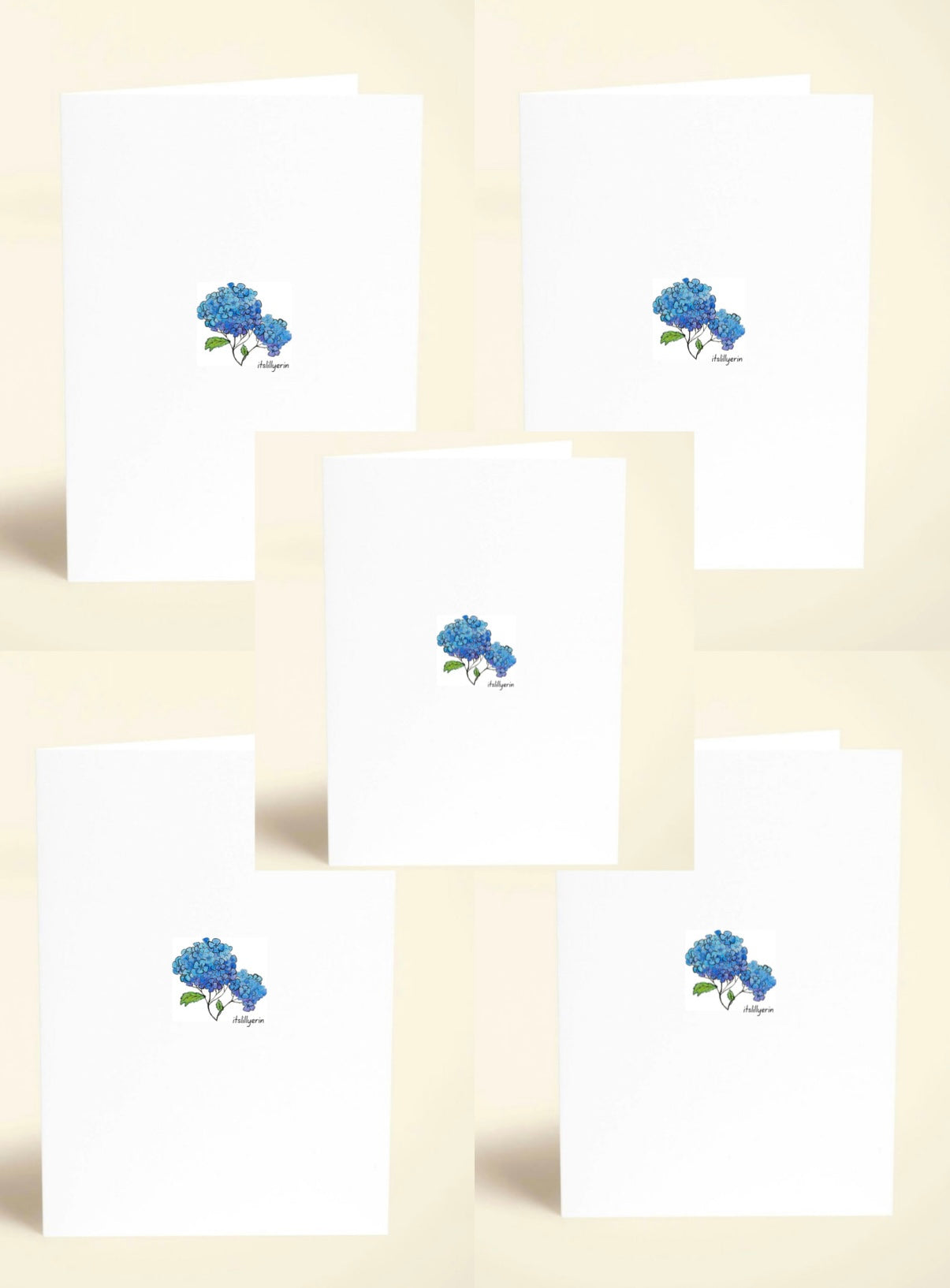 Set of white cards with blue floral designs on a beige background