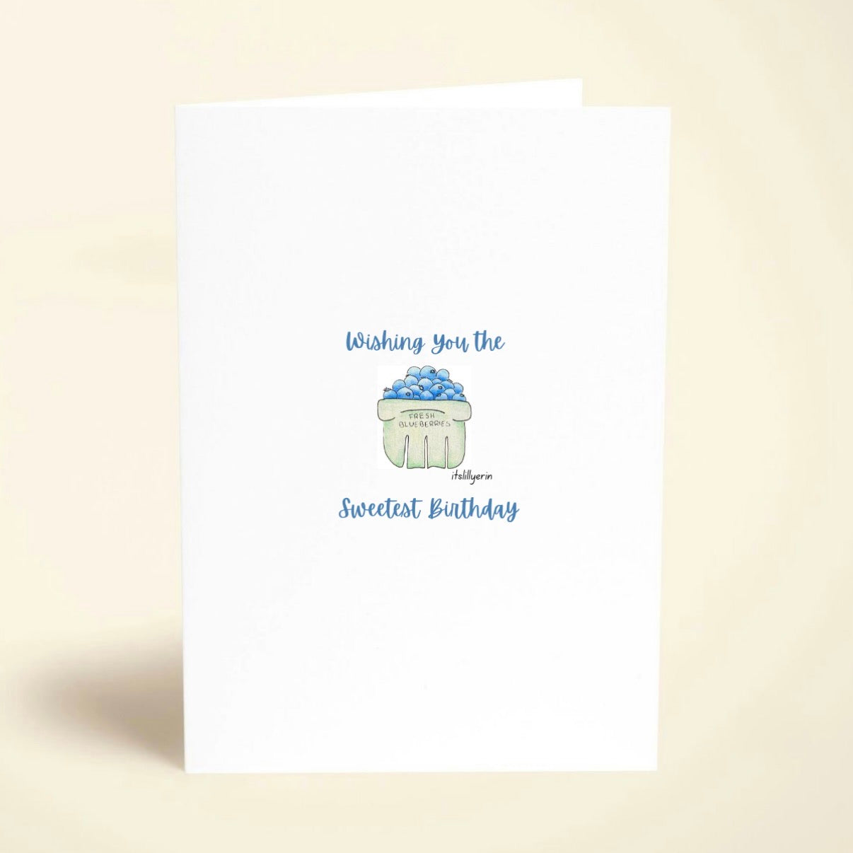 Greeting card with birthday message and cupcake illustration on a beige background