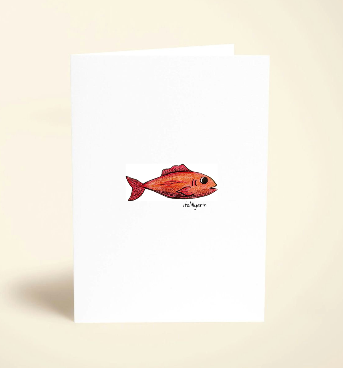 Note card with a red fish illustration on a beige background